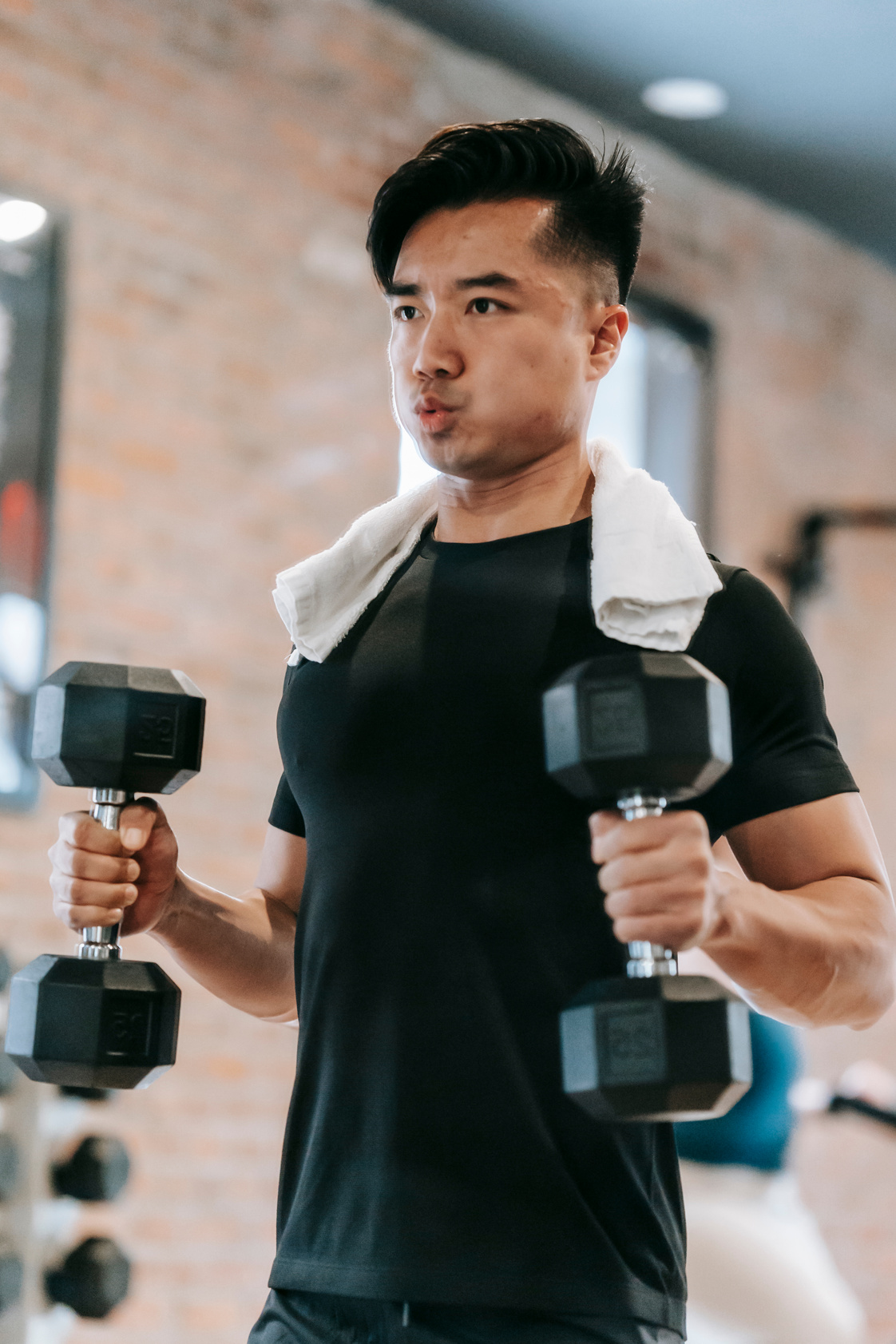 Muscular Asian man working out heavy weights