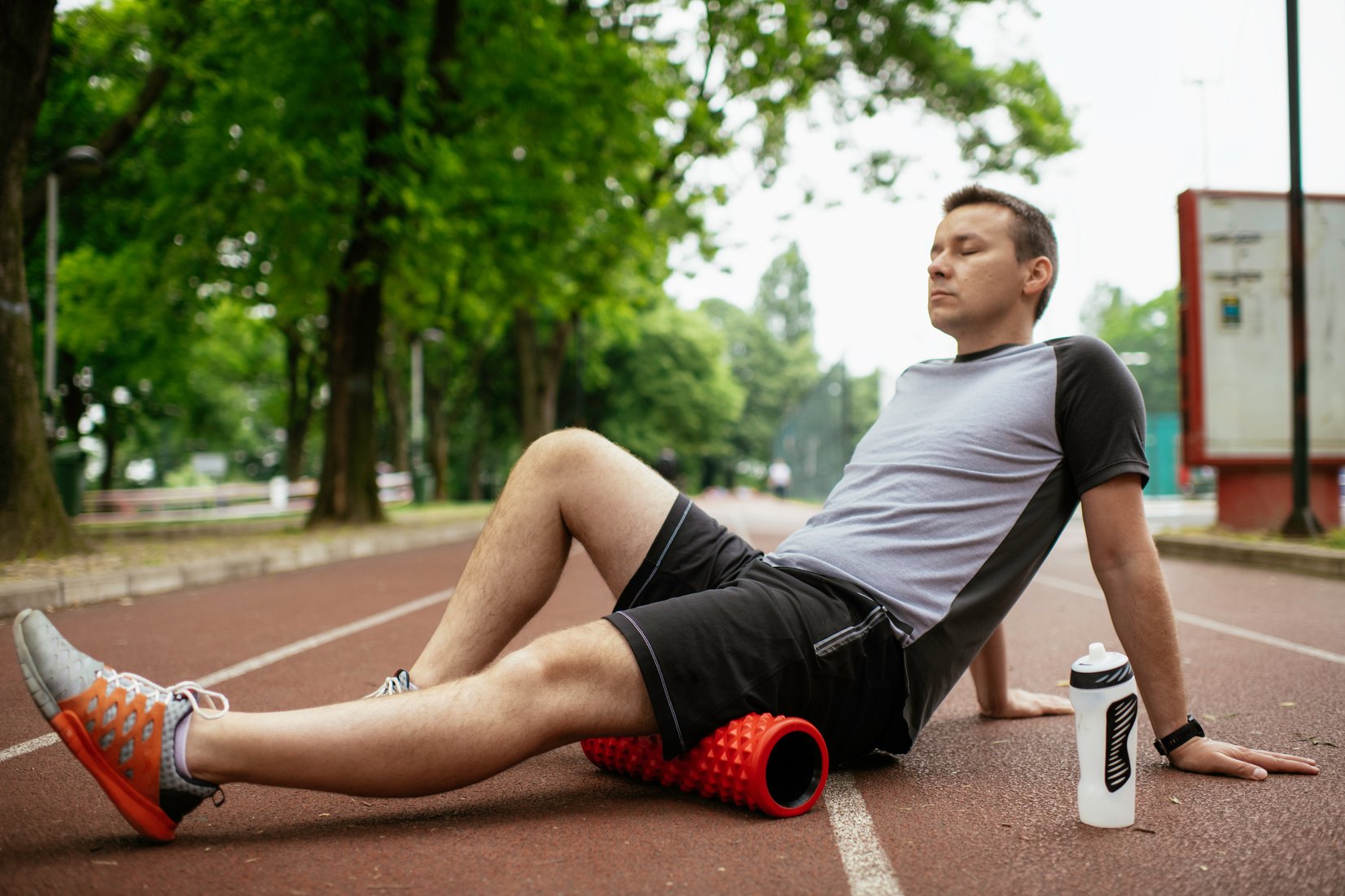 Man foam rolling. Athlete stretches using foam roller.